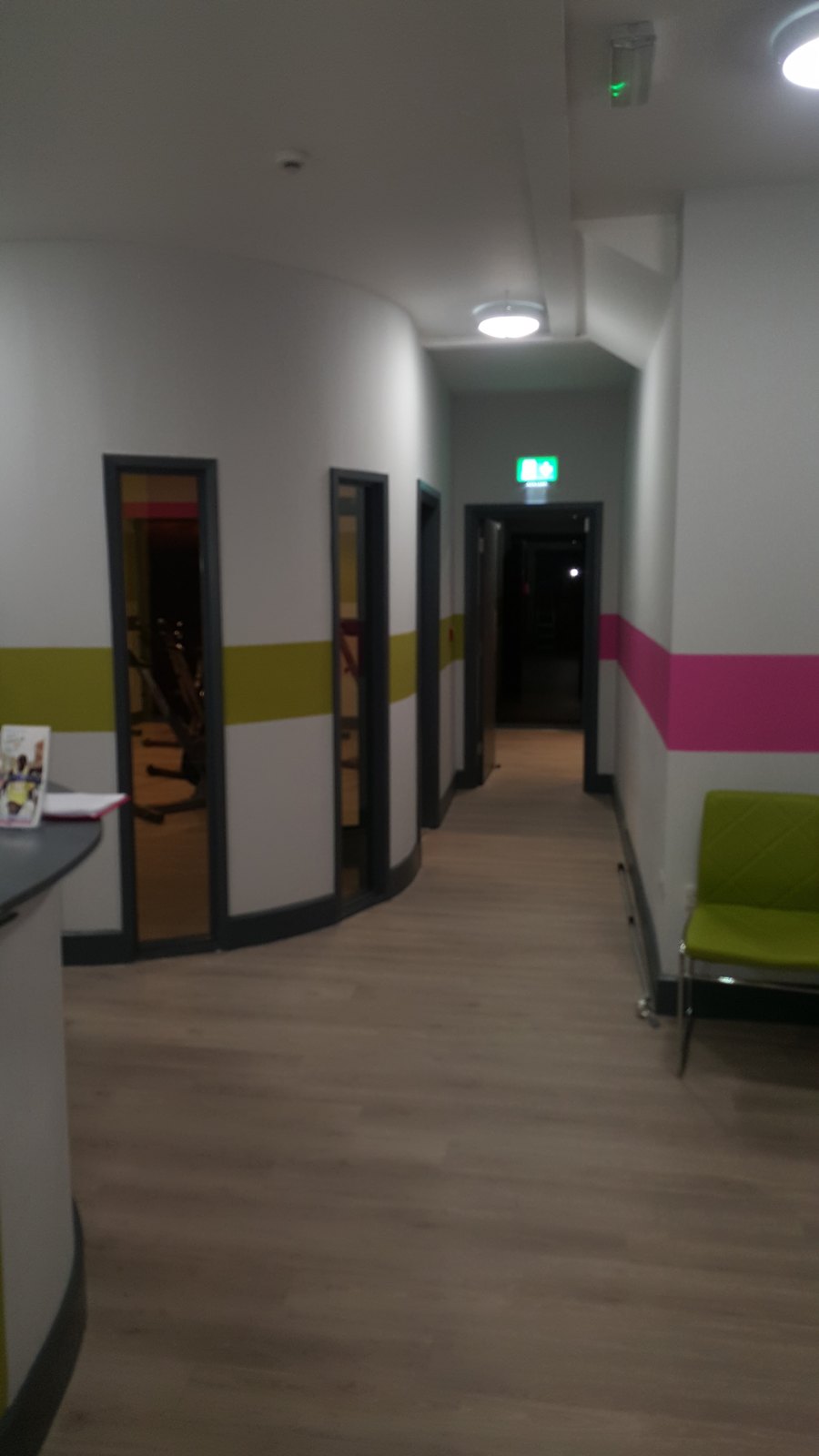 A corridor with ceiling lights and an exit sign